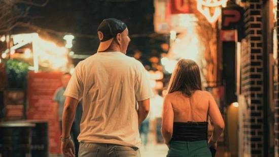 Couple walking together on a lit street in the evening